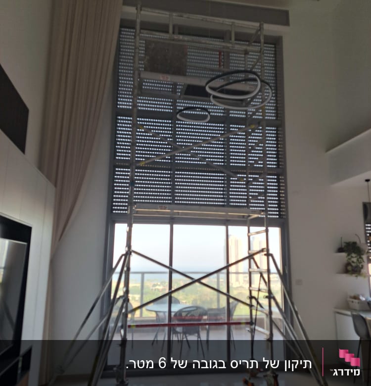 תריסים מוגפים עם פיגום בחזית חלון גדול